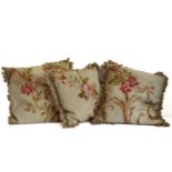 A pair of cushions in an antique tapestry-effect floral fabric edged with pom-pom braid (40cm