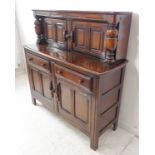 A reproduction elm court cupboard in 17th century style: two panelled doors flanked by two cup and