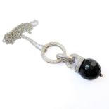 An unusual heavy silver pendant mounted with a faceted cut-glass / hardstone dropper on rings and