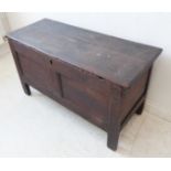 An 18th century oak chest with restorations; hinged planked top above a two-panel front and sides