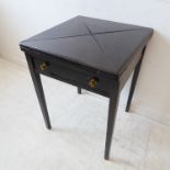 An early 20th century fold-over top mahogany envelope-style card / games table raised on square