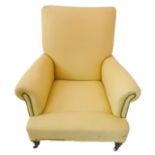 A late 19th century fireside-style upholstered armchair in the style of Howard: short, turned