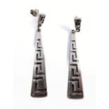 A pair of silver earrings of elongated conical form with a Greek key style pattern