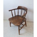 An early 20th century elm-seated smoker's bow armchair; the slightly splaying turned legs with