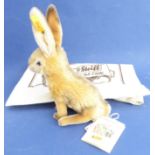 A mohair Steiff hare: seated upright, with usual button in ear and with original accompanying