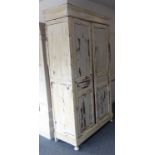 A 19th century French painted armoire of tall proportions: the cornice above two panelled doors