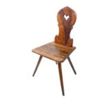 An interesting 19th century fruitwood primitive chair: the angular rigid back centrally pierced with