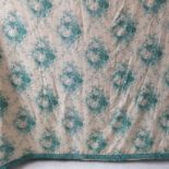 A pair of curtains in a cream and green patterned silk effect damask with a green floral print,
