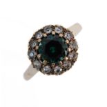 A 9-carat gold ring set with a central green stone surrounded by white stones, ring size T (boxed)