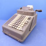 A mid-20th century adding machine by Burroughs; push number grid, side calculating handle and