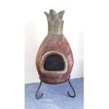 A terracotta chimenea on shaped iron stand: approx. 112cm high including stand