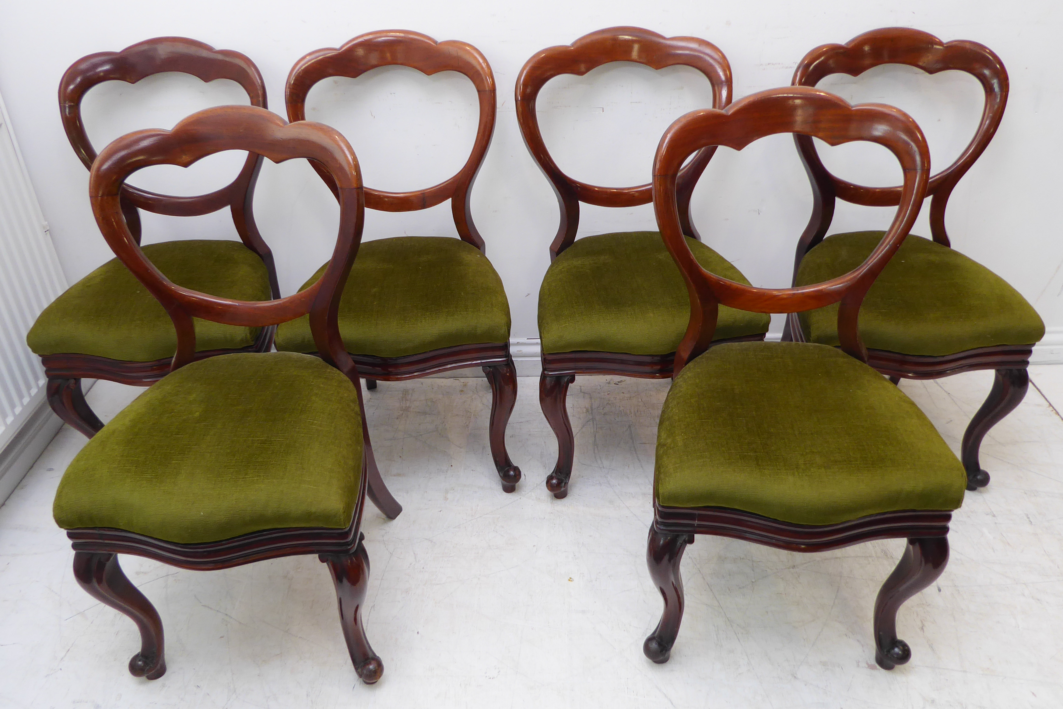 A harlequin set of eight mid-19th century mahogany balloon-back chairs: six with drop-in green