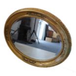 A 19th century style (modern reproduction) oval gilt framed wall-hanging looking glass having hand-