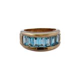 A heavy 9-carat gold band ring set with blue topaz, ring size J/K Condition Report: Under a normal