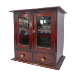 A late 19th/early 20th century mahogany table cabinet: the moulded top above two glazed doors