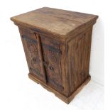 A small Eastern-style hardwood cabinet: two-plank top above two doors carved with concentric wheels,