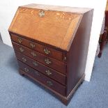 A mid-18th century oak writing bureau: the angular cleated fall opening to reveal fitted interior of