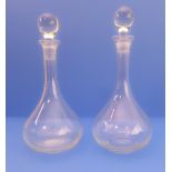 A matched pair of decanters with onion bodies, slender necks and slightly differing stoppers) (