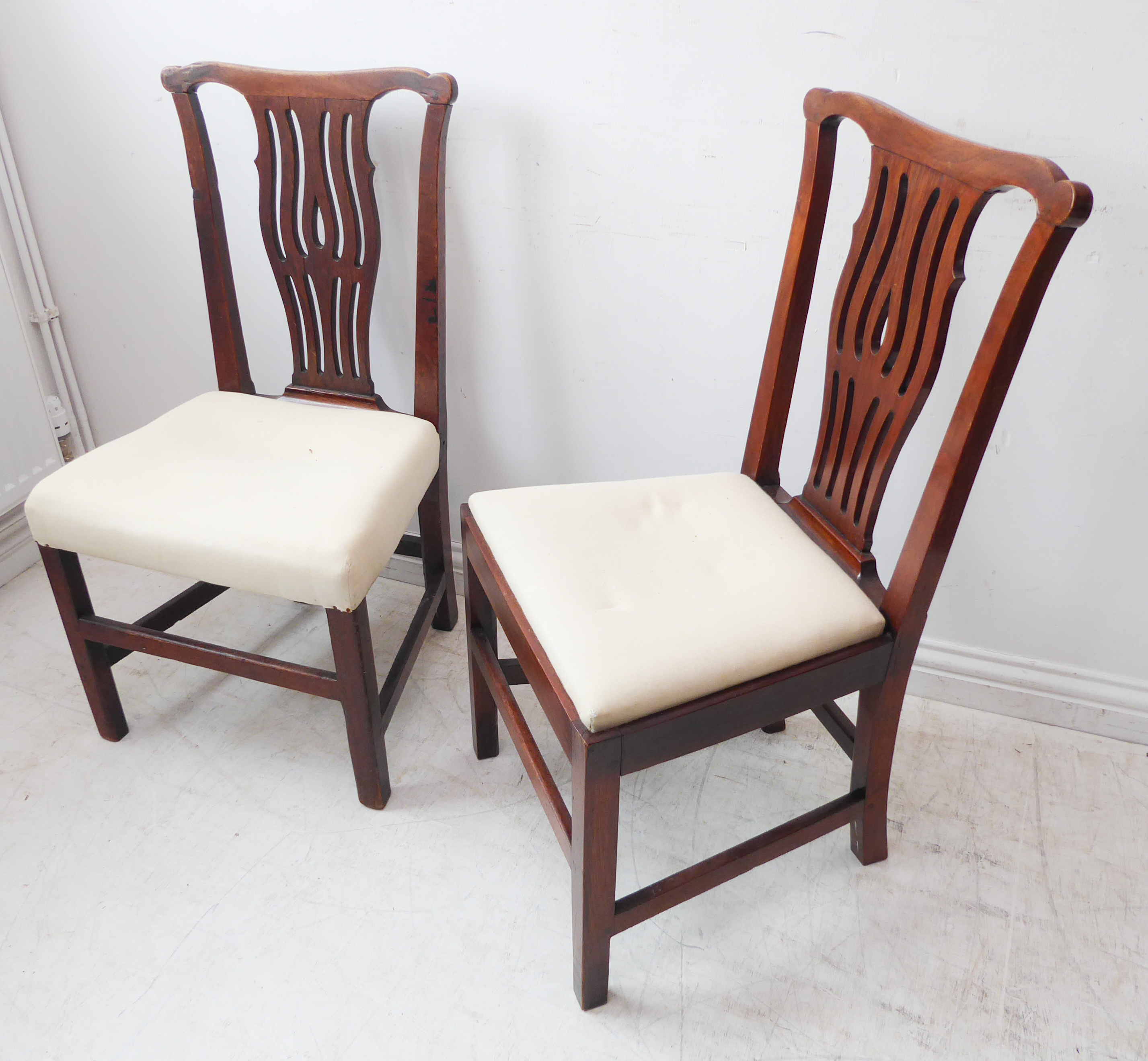 A pair of 18th century walnut side chairs; shaped top rails, pierced splats, overstuffed seats and