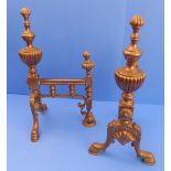 A pair of 19th century copper andirons: of fluted urn shape above a lower scallop shell motif and