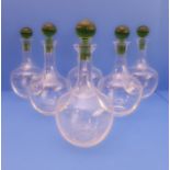 A set of six Murano decanters; clear-glass onion bodies and green-glass stoppers (28cm high)