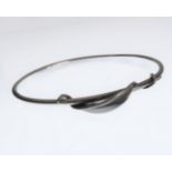 A silver bangle with a spiralling leaf twist design