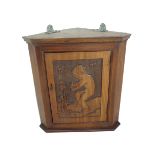 A late 19th/early 20th century hanging mahogany corner cupboard: the single panelled door carved and