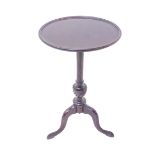 An early 20th century mahogany wine table in Georgian style: the dished-top above turned stem and