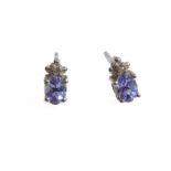 A pair of silver stud earrings mounted with tanzanite stones and (possibly diamond) chips