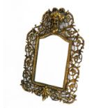 A late 19th / early 20th century ornately pierced brass mirror: the pediment with green-man-style