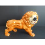 A mid to late 19th century standing lion Staffordshire pottery figure (36 cm wide)