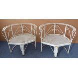 An unusual pair of wrought, hammered and cast iron white-painted garden tub chairs loosely in the