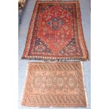 A hand-knotted Eastern rug with central blue ground lozenge against a larger red ground with
