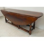 A large and very fine reproduction (in 18th century style) oak oval harvest table: two drop leaves