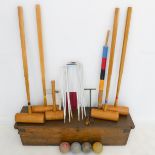 A cased croquet set to include five mallets, balls, pegs and hoops