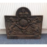 A heavy cast-iron fireback decorated with the royal coat of arms and Latin Legend (75cm wide x