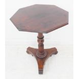 An antique mahogany occasional table: octagonal top above turned stem, triform base terminating in