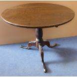 An early 19th century circular oak tilt-top occasional table, turned stem and tripod base with