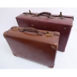 A red-leather suitcase and a similar smaller example (61 cm and 46 cm wide)