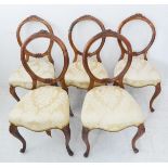 A set of five mid-19th century walnut balloon-back chairs: each top rail carved with flowers and