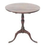 An early 19th century circular oak occasional table: turned stem and pronounced and slender tripod