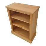A modern pine bookcase in 19th century style: overhanging top and shelves above plinth base (71cm