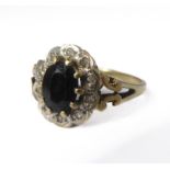 A yellow-gold dress ring centrally-set with a dark blue oval stone (possibly a sapphire) and