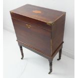 An early 19th century mahogany and boxwood strung cellarette on stand: the hinged lid with shaped-