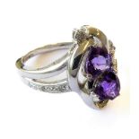 A hallmarked-silver dress ring vertically set with two-shaped amethysts surrounded by small diamonds