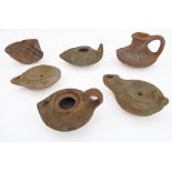 A collection of six Roman terracotta oil lamps of various forms: three with pronounced handles and