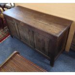 A large early 18th century oak chest: moulded three-plank top opening to reveal left-hand candle-