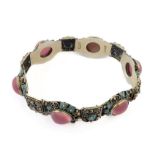 An unusual silver bracelet of articulated form set with red hardstones polished en cabochon