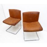 A pair of original mid-20th century tan-leather upholstered chairs with shaped chromed steel