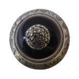 A circular late 19th/early 20th century white metal brooch: engraved border and with marcasites